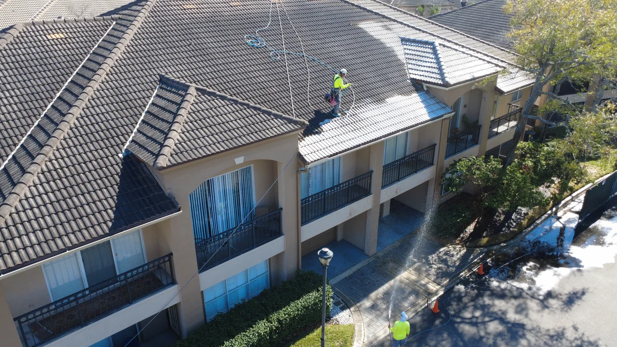 Commercial condo complex roof cleaning with two technicians using fall protection in Tampa Harbour Island