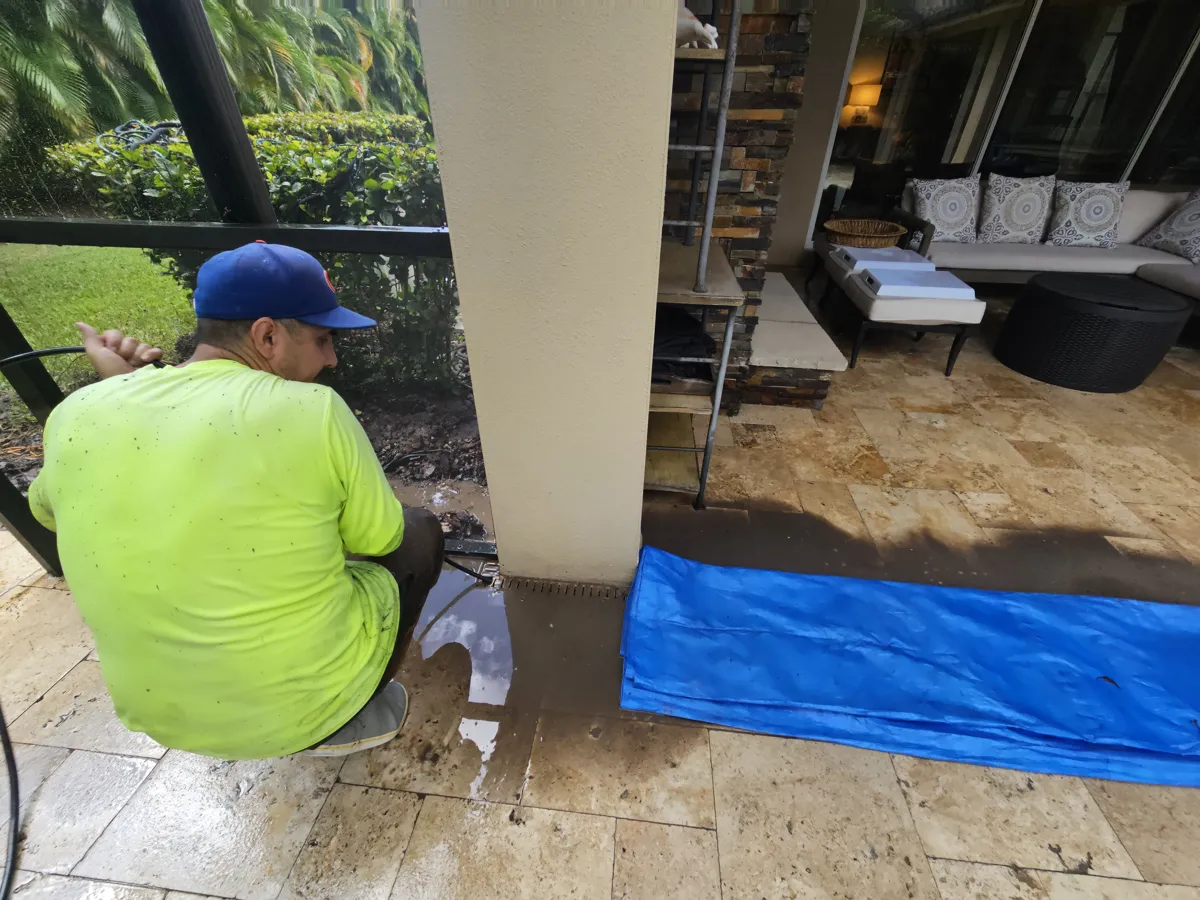 Brian Vasquez hydro-jetting a pool lanai drain to prepare for hurricane season in Florida