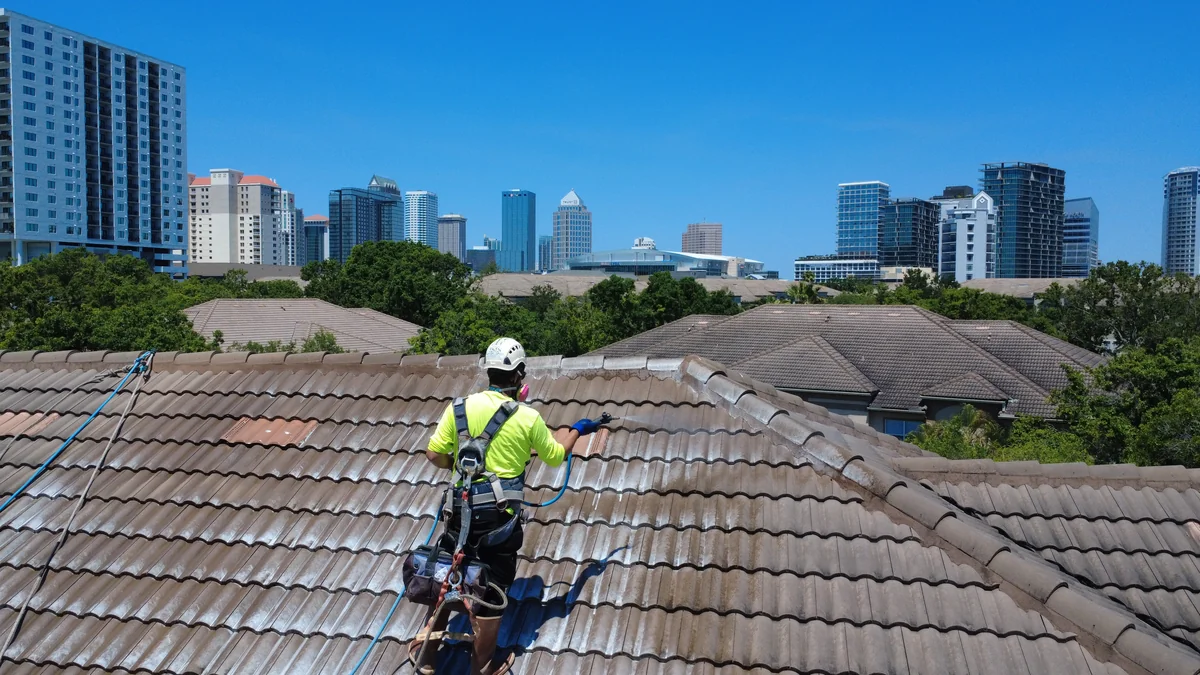 Soft wash roof cleaning of barrel tile roof with downtown Tampa skyline in background