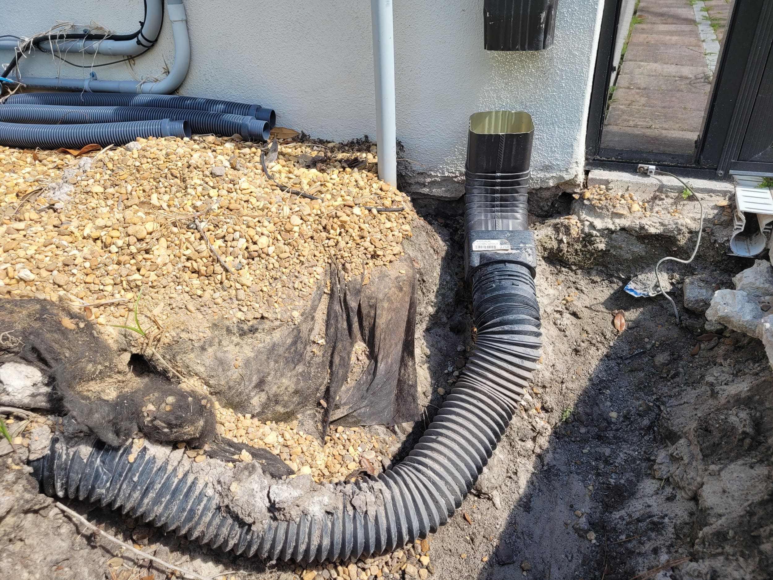 Clogged French drain connected to a gutter downspout, dug out and exposed in Clearwater, FL