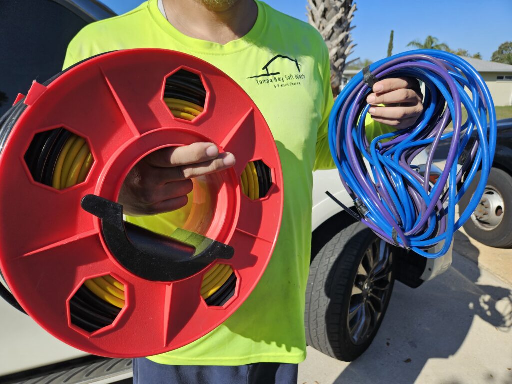 Holding four different types of water-fed pole hoses for comparison.